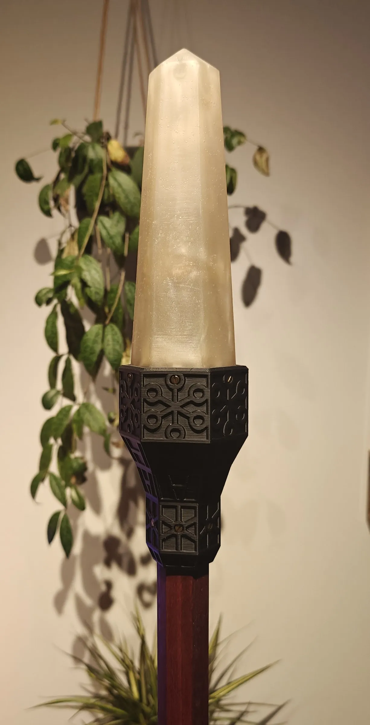 Black Art Deco topper holding a pale pointed crystal