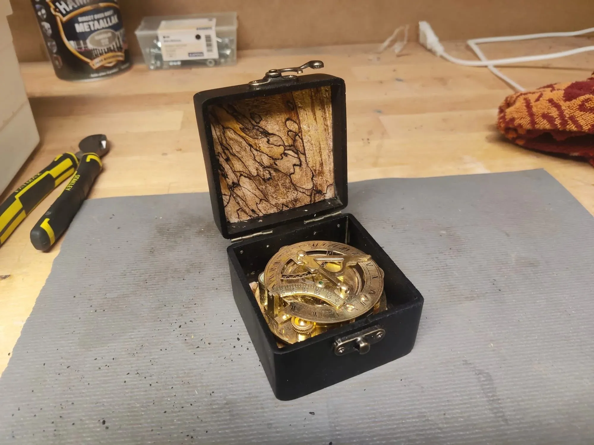 The box open at an angle with the compass inside