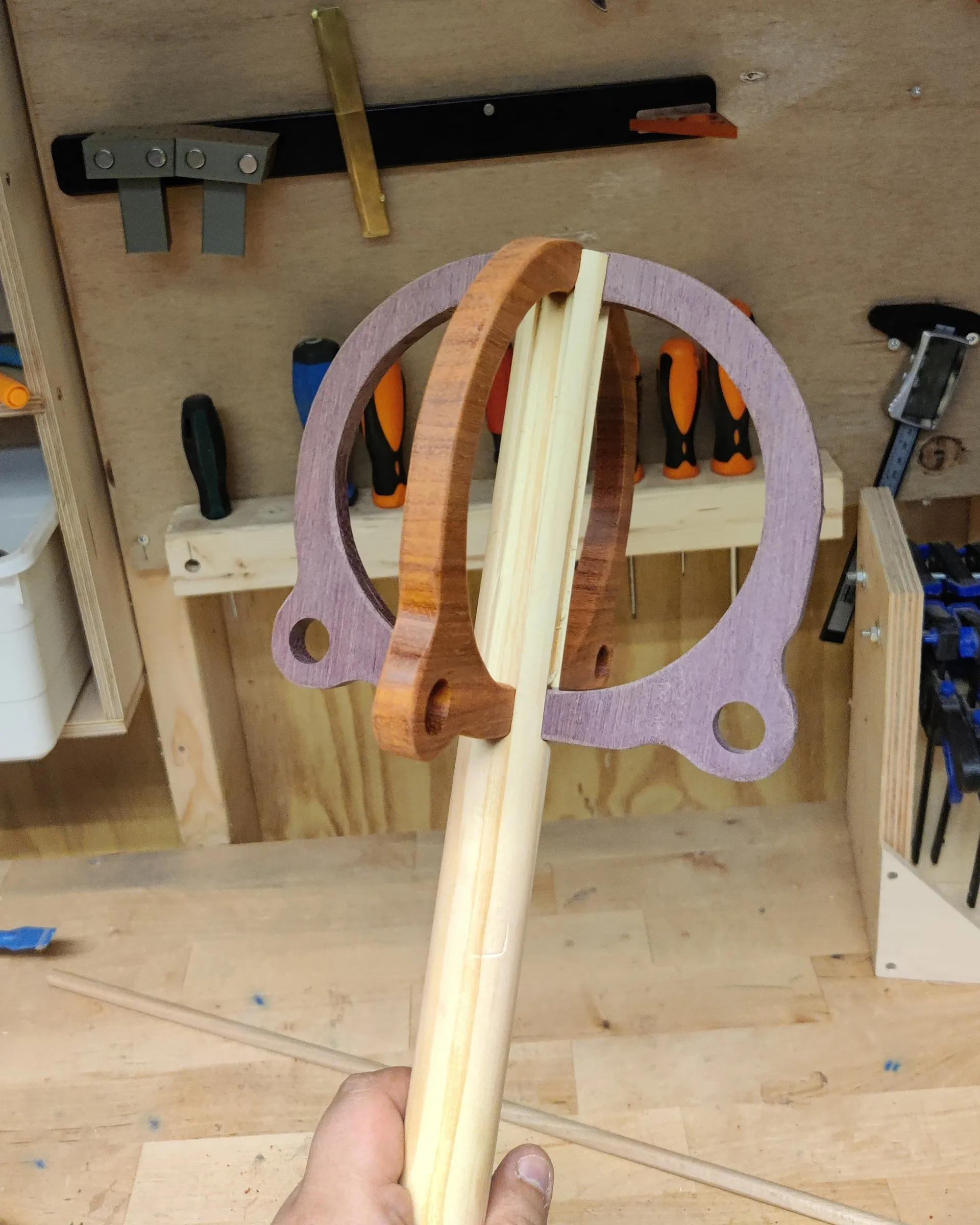 Test-fitting the wooden rings of the first topper onto a pale shaft in the workshop