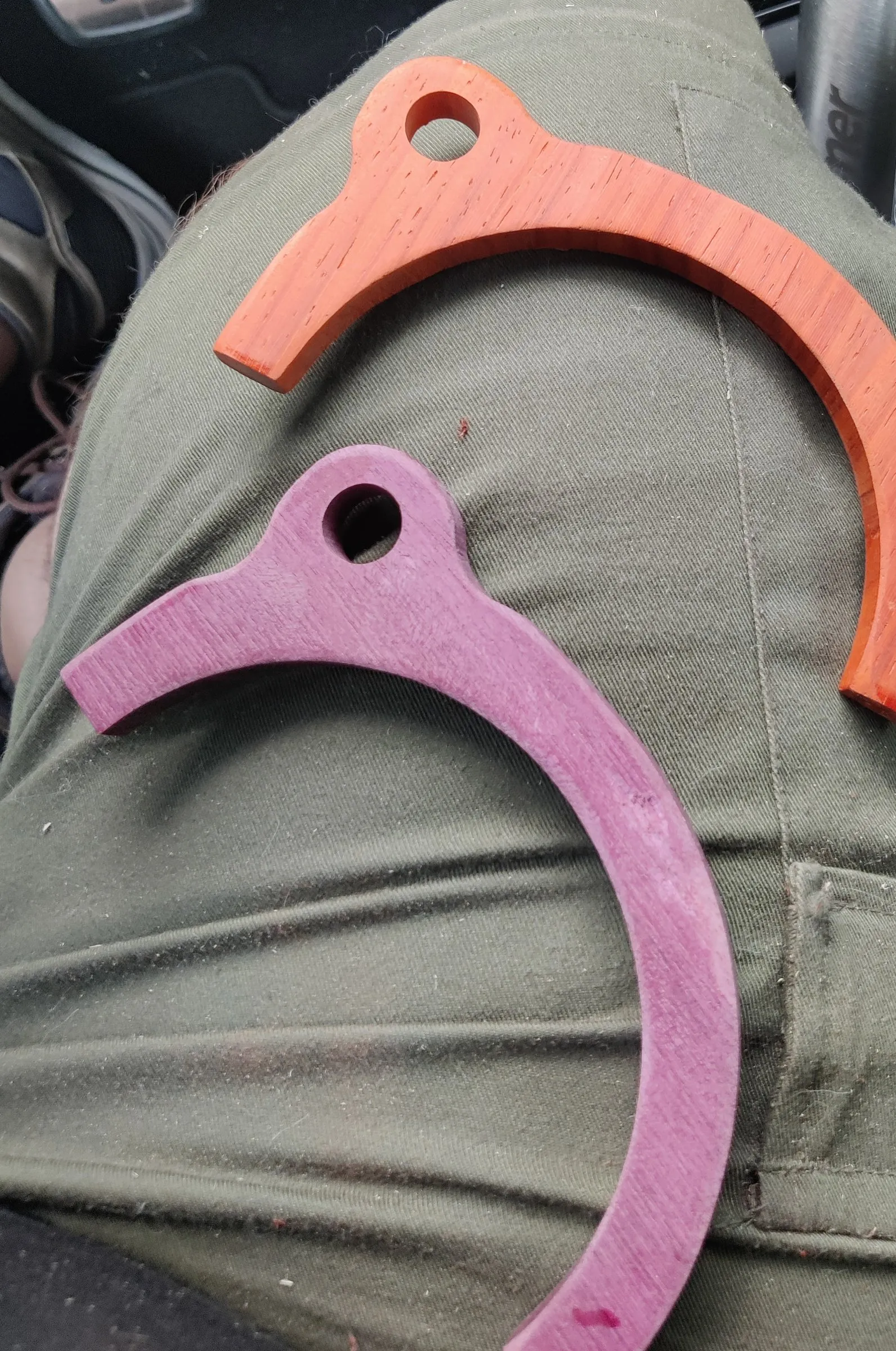 Two cut and sanded wooden rings, one purple and one orange