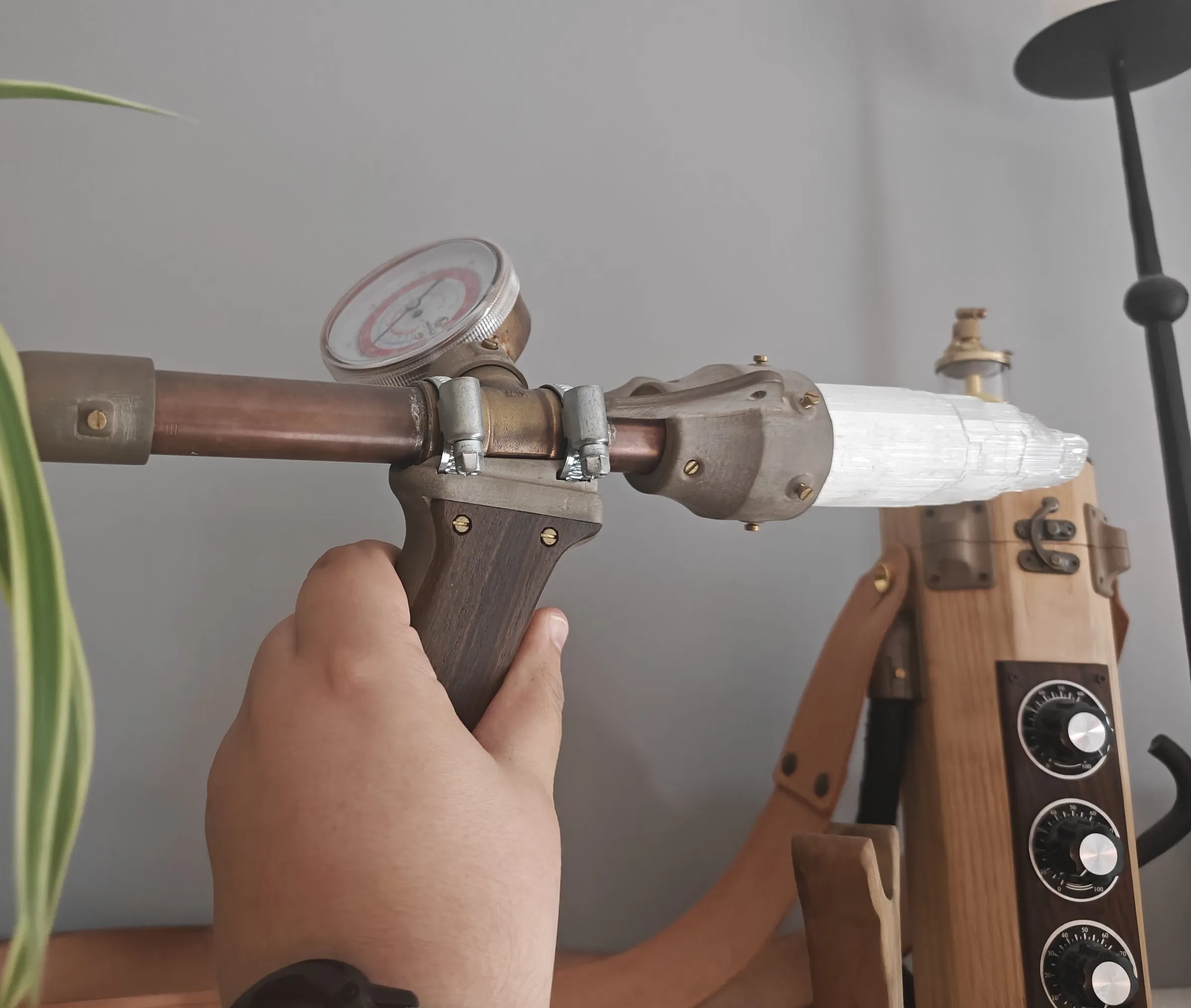 The wand held in a hand, showing the copper tube and pressure gauge