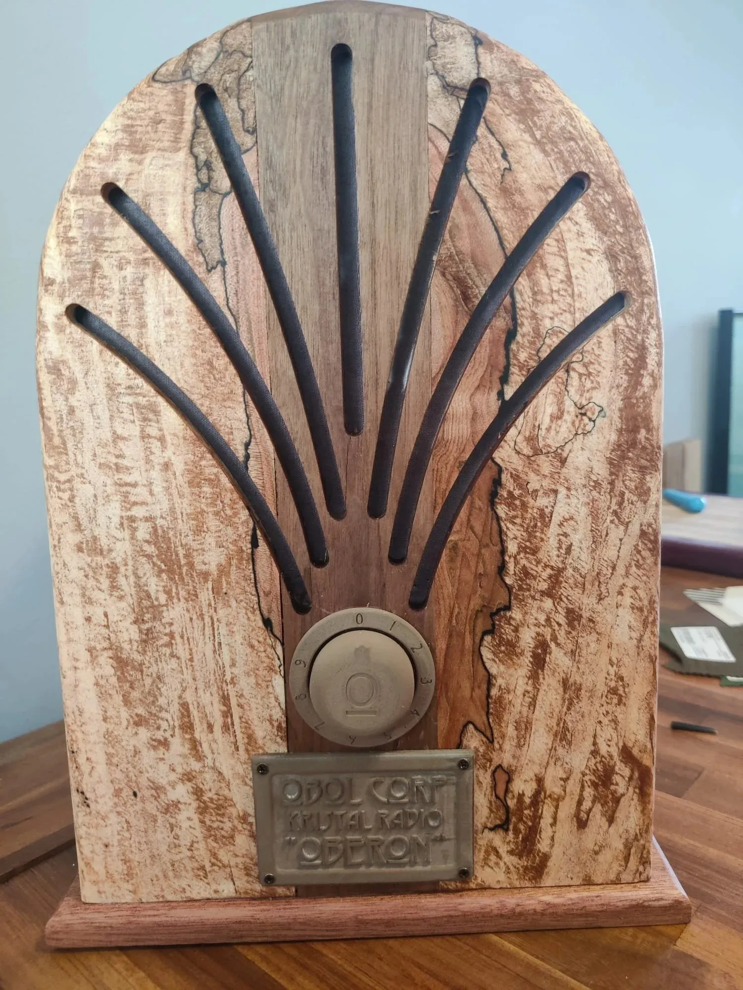 Arched radio with a spalted maple front, dark walnut slats and a round brass knob