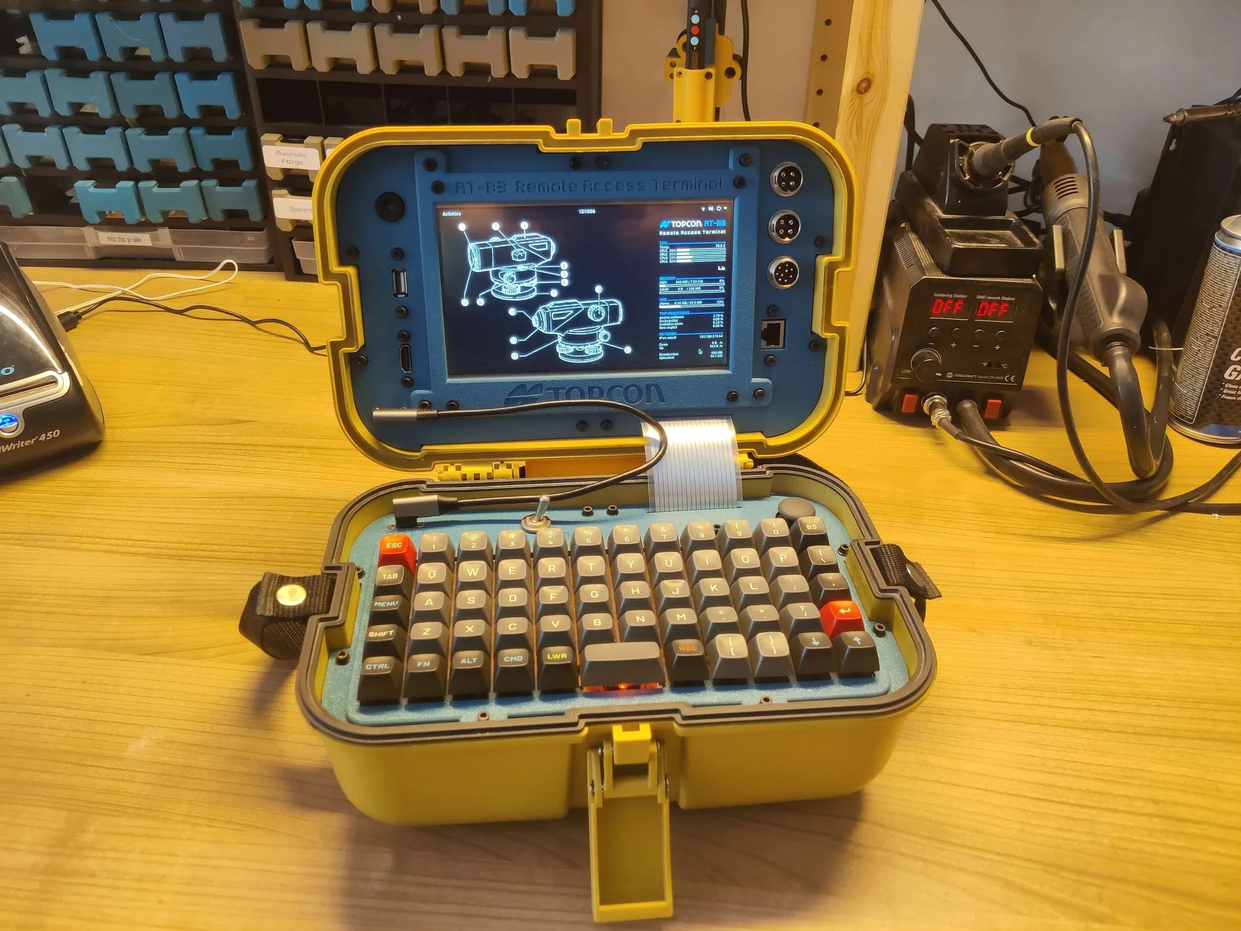 Open yellow TOPCON case with a screen in the lid and a mechanical keyboard in the base