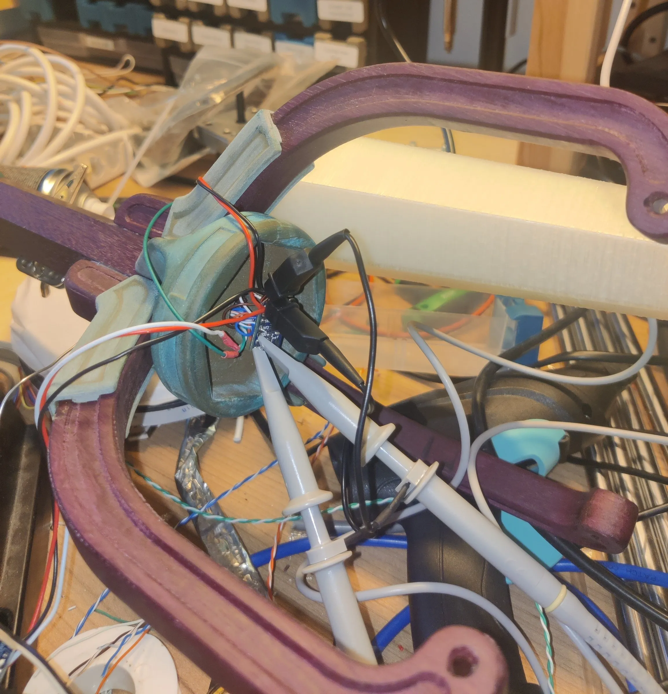 A topper on the workbench with test probes clipped to its electronics
